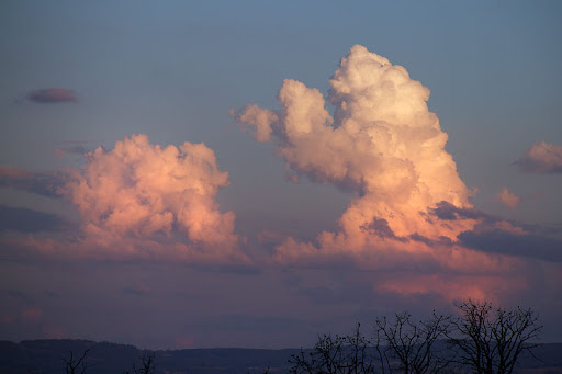 Två moln på himlen. Med lite fantasi ser det ut som en björn som står på bakbenen och boxar med sina ramar mot en gris