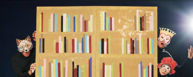 Tre figurer med masker på huvudena tittar fram ifrån en vägg som är målad som en bokhylla. Bakgrunden är svart och figurerna är klädda i svart. Den vänstra figuren har en vargmask, den översta högra har en mask med ögon och krona på huvudet och den nedersta till höger en mask med ögon och röd hatt.