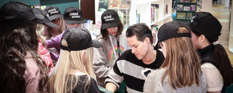 Robin Werner, mest känd under sitt artistnamn Elecktra, omgiven av barn med Minibladet-kepsar.