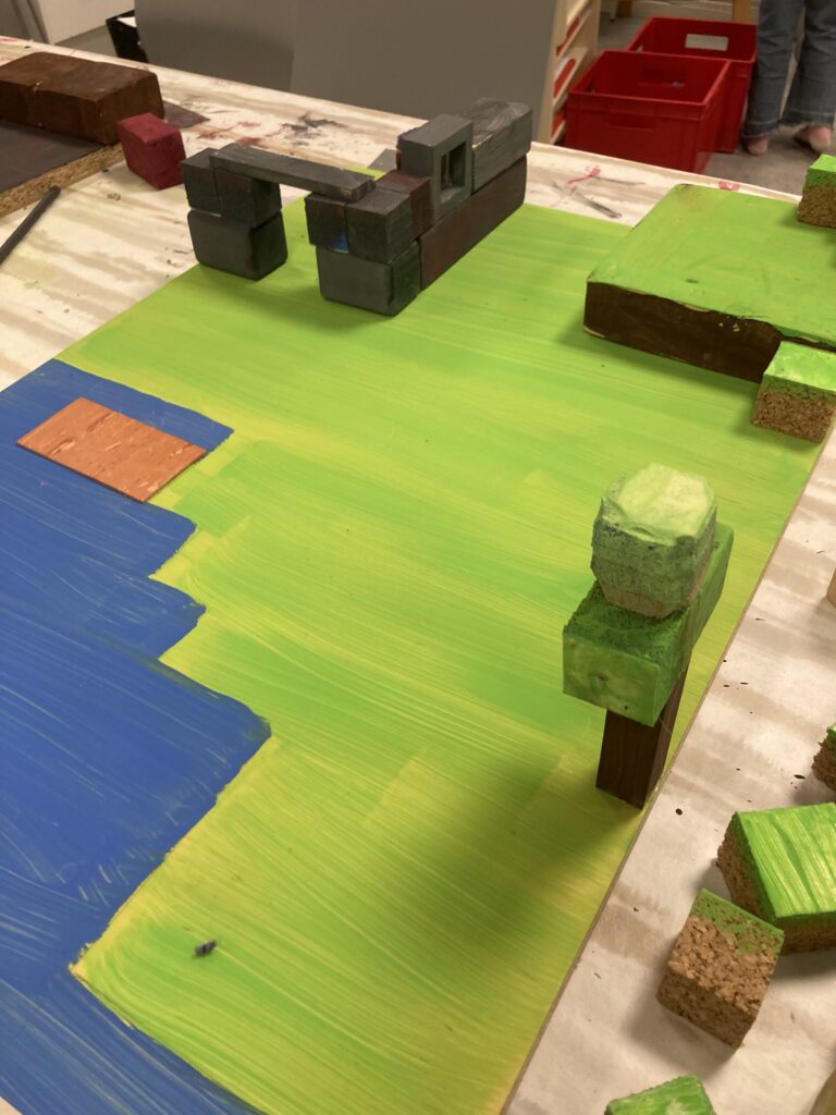 En minecraft-liknande spelbricka med en spelpjäs. Allt är i grönt och blått.