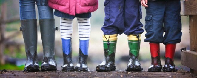 Fyra par barnben i stövlar.