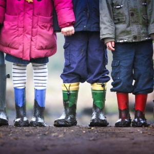 Fyra par barnben i stövlar.