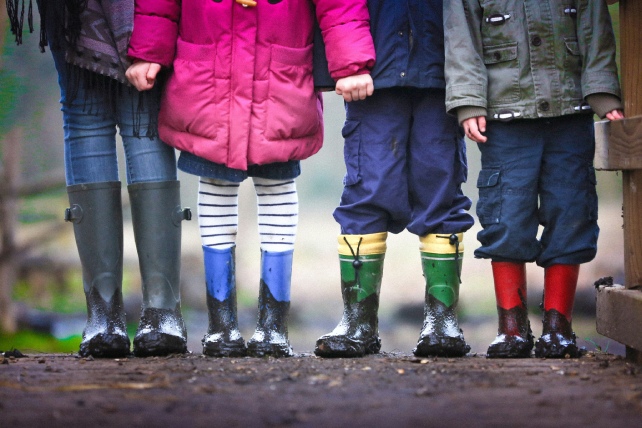 Fyra par barnben i stövlar.