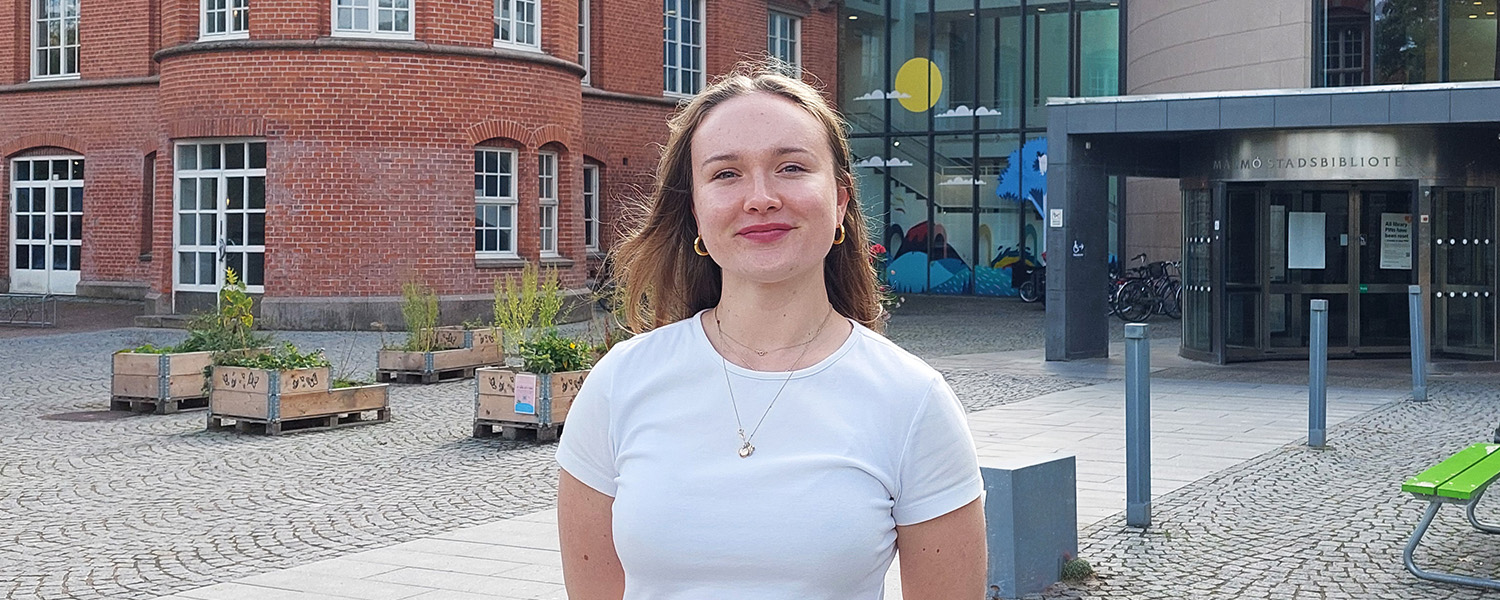Foto. Tova står utanför Malmö stadsbibliotek.