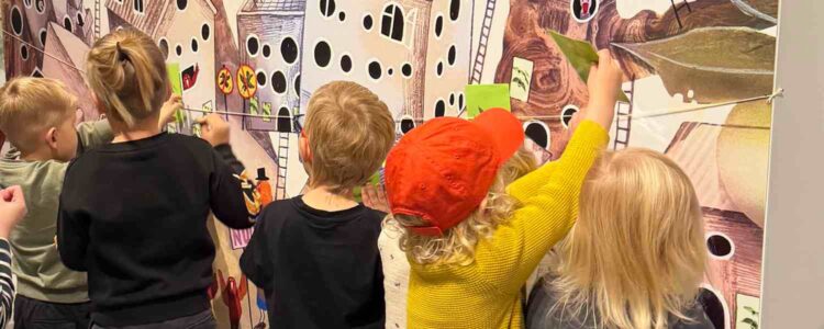 Barn interagerar med utställning på museum.